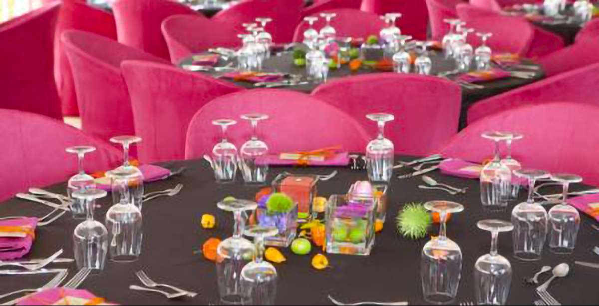 Tables with cutlery and glasses and pink chairs