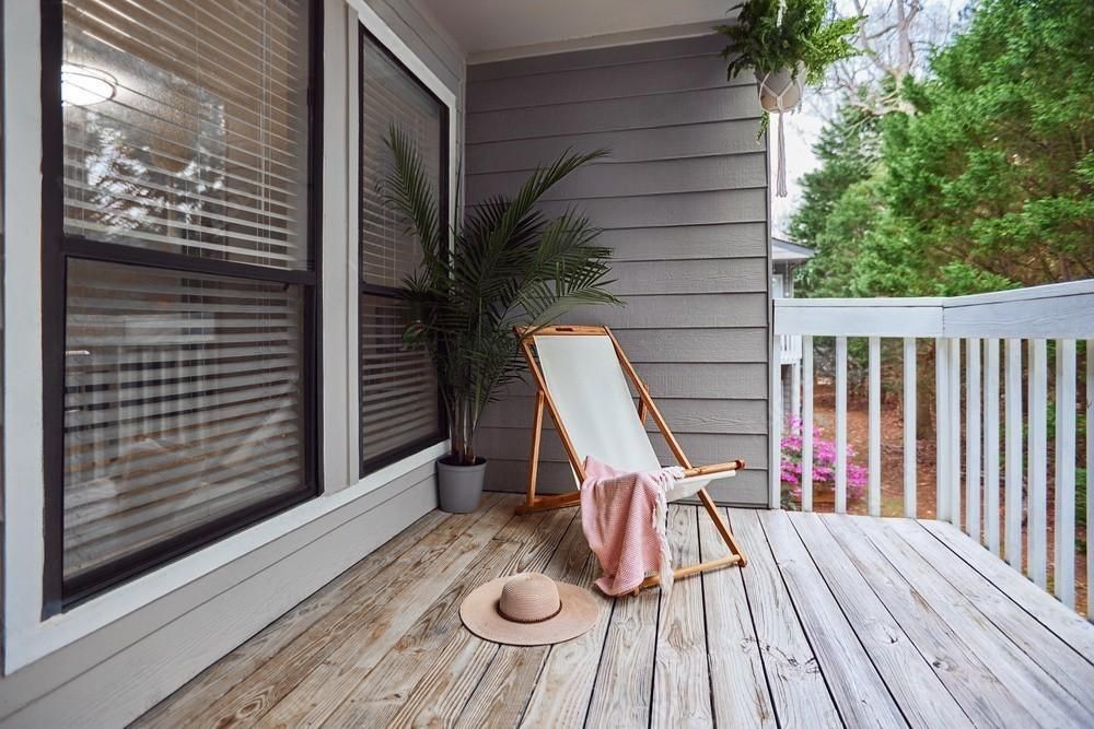 There is a deck with a chair and a hat on it.