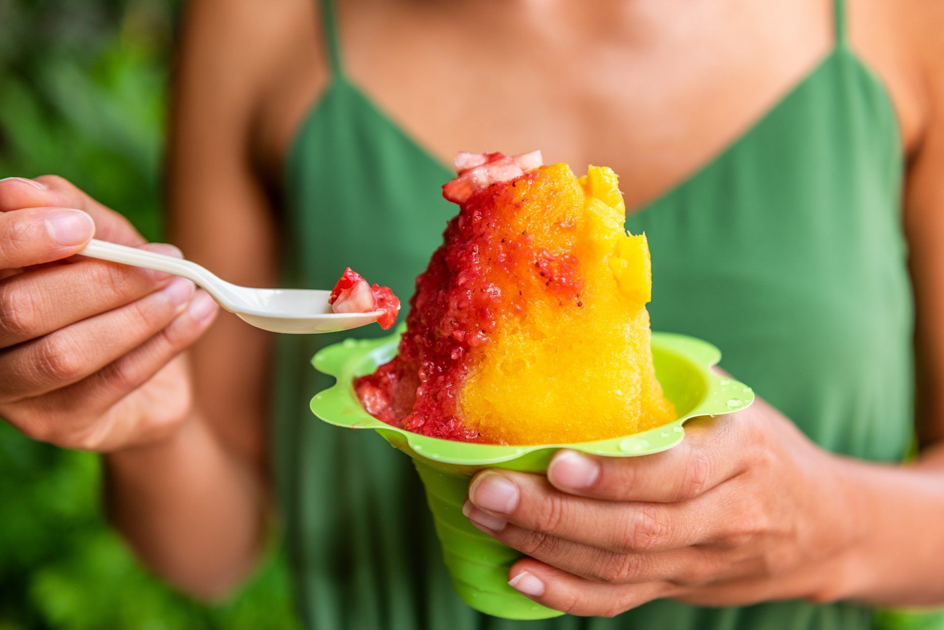 Shave Ice Hawaii local food woman eating hawaiian shaved ice cream treat in Honolulu Waikiki beach, Hawaii , USA.