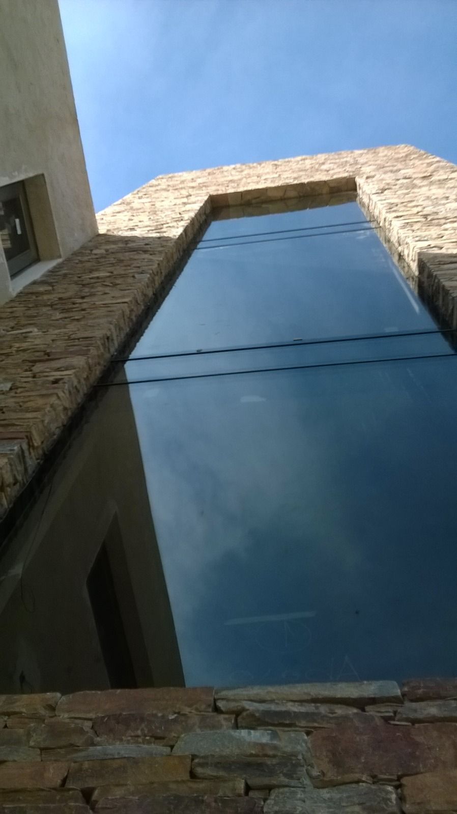 Obreros construyendo un edificio moderno con una marquesina de metal gris y grandes ventanales.