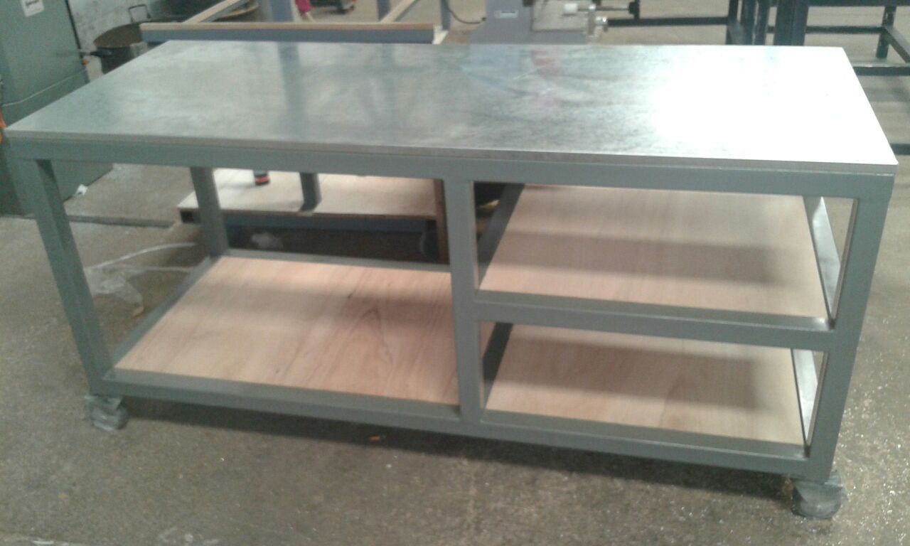 Mesa de trabajo metálica con tablero de acero inoxidable y estantes abiertos de madera en la parte inferior.