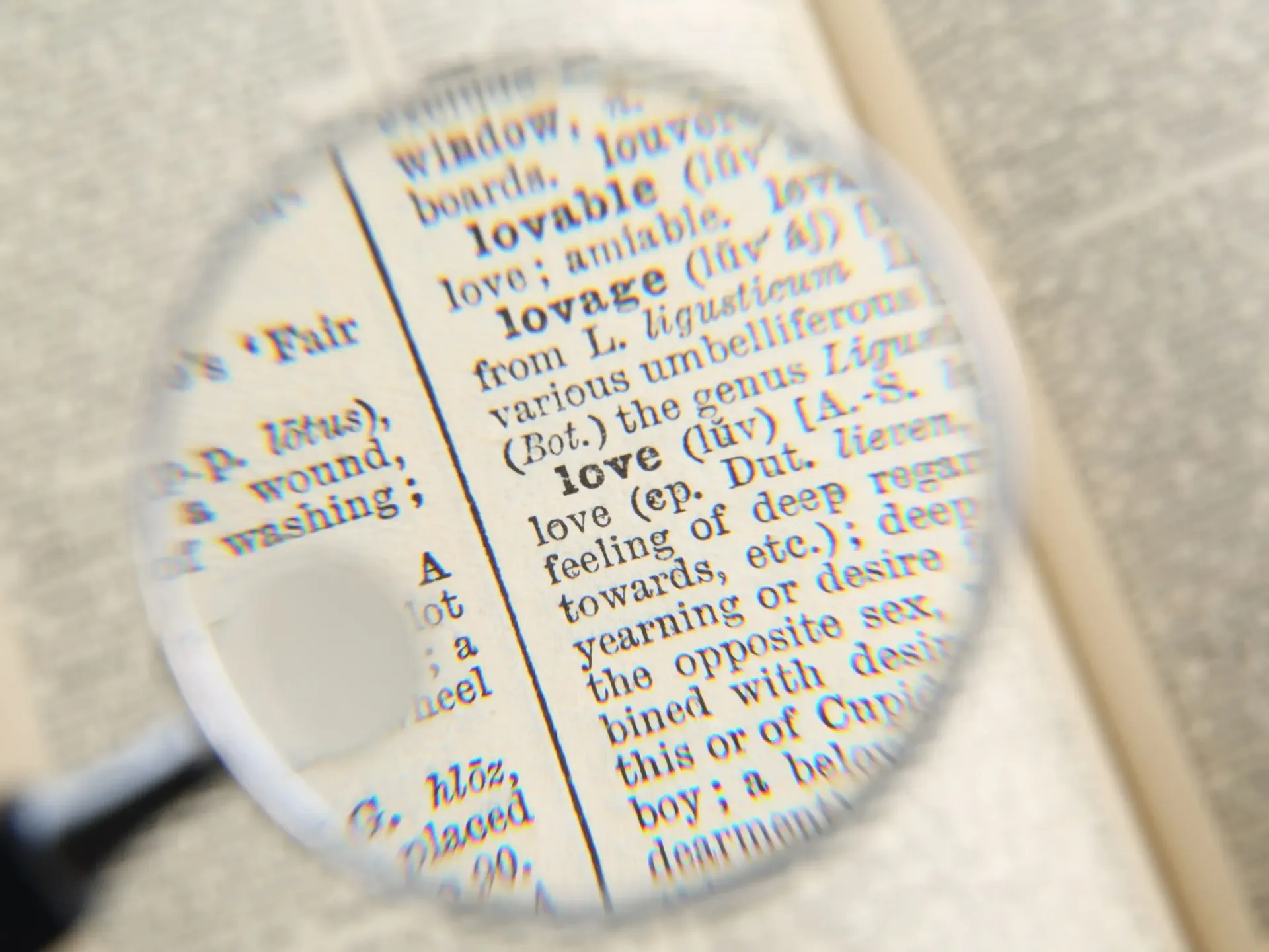 Magnifying glass over an open dictionary, focusing on the definition of
