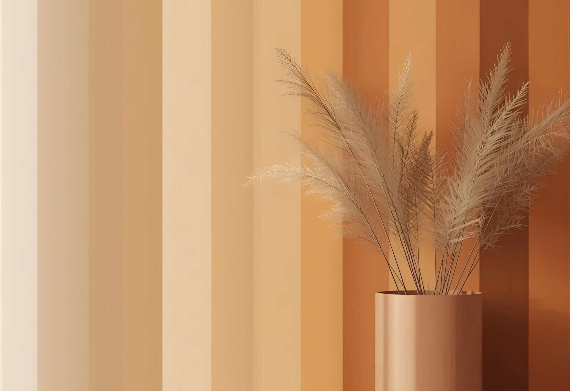 Vase with tan reeds against a striped wall of varying warm beige and orange tones.