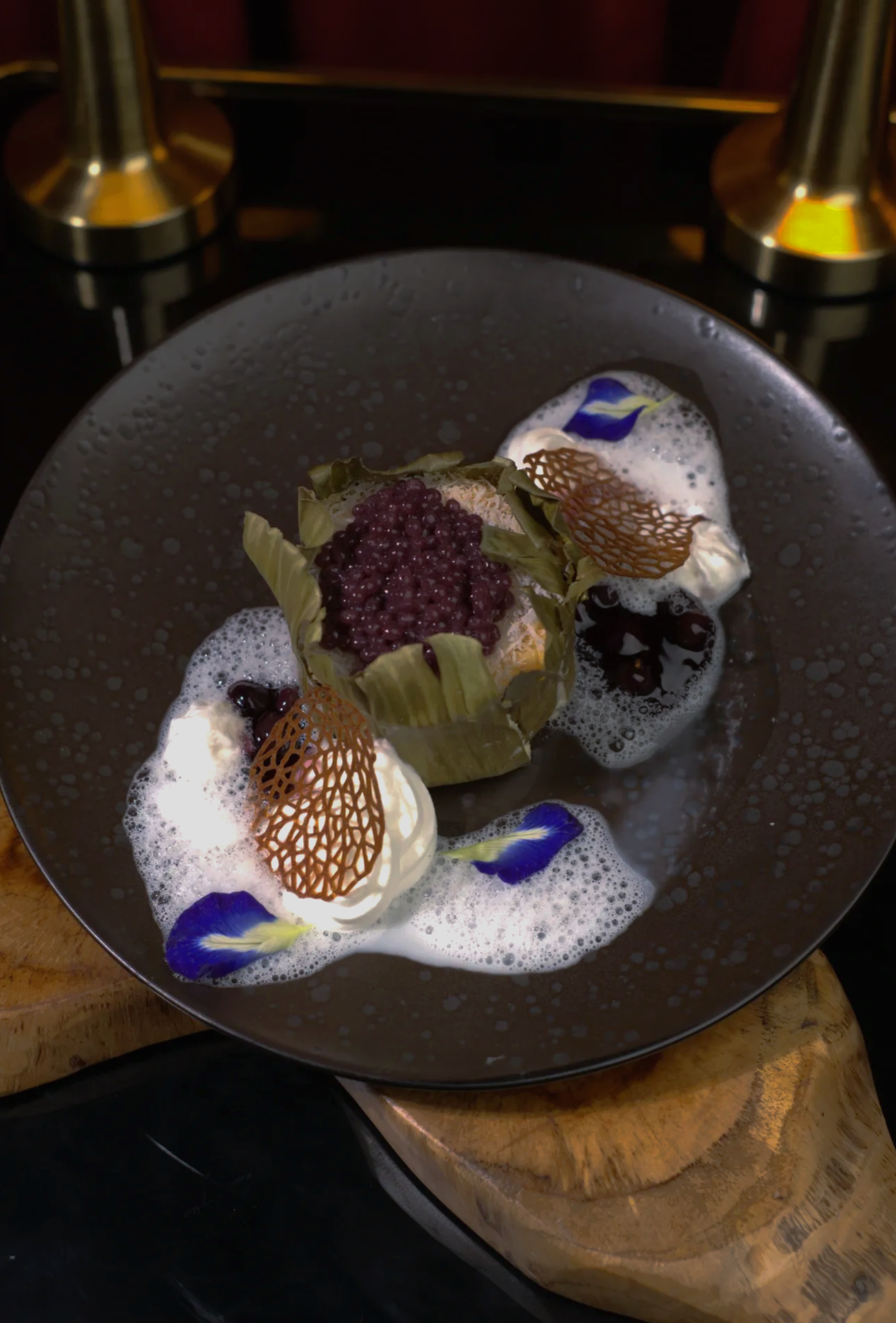 Dessert on plate: white mousse with cherry topping, caramel crisp, and fresh cherries.