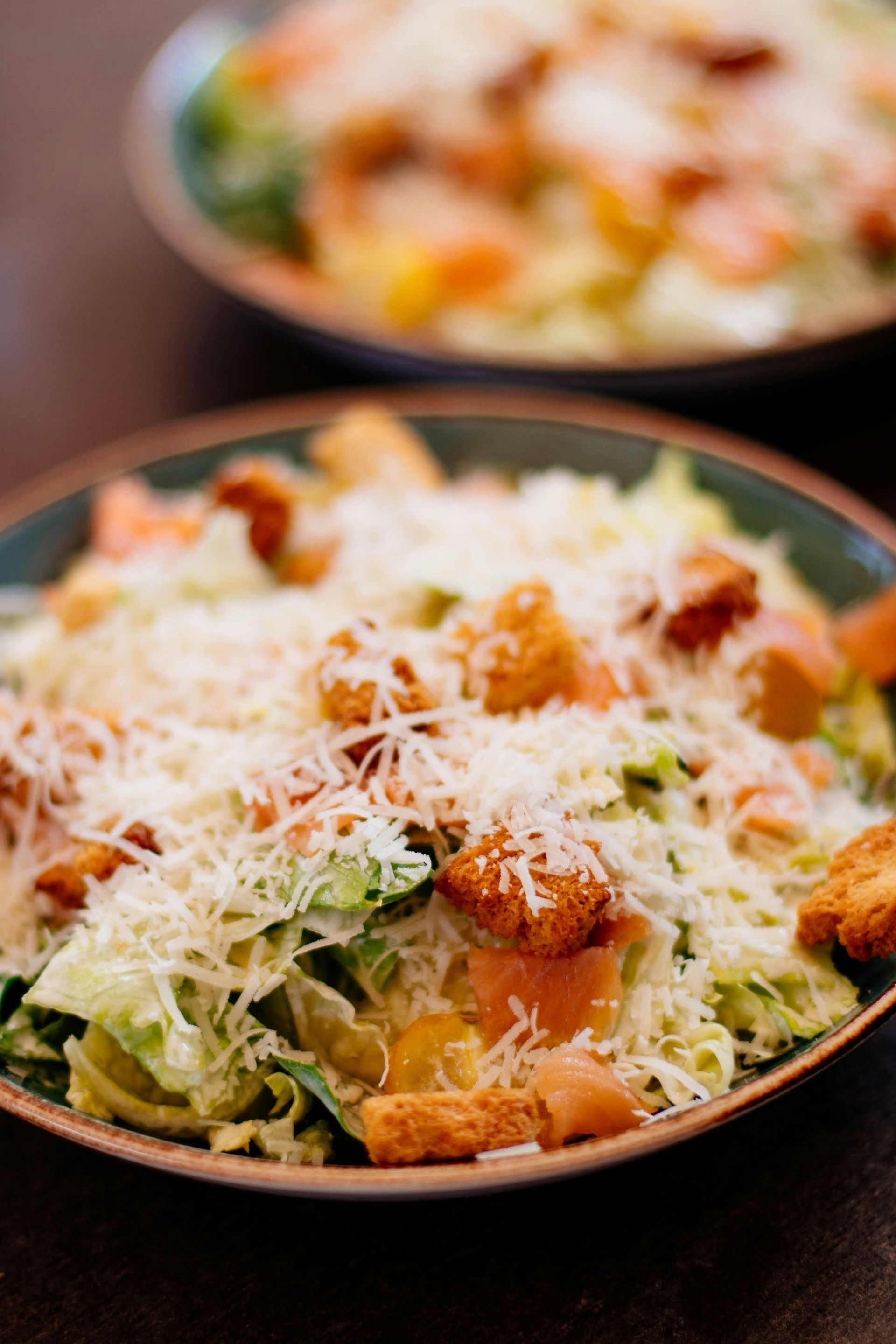Caesar salad with croutons and shaved parmesan cheese in a bowl.