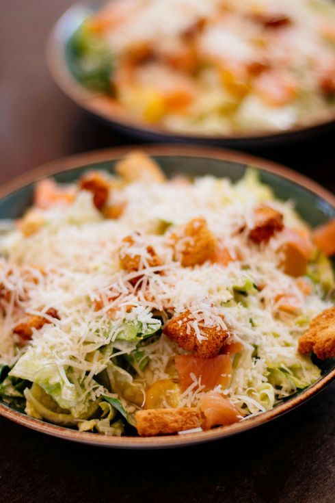 Caesar salad with croutons and shaved parmesan cheese in a bowl.