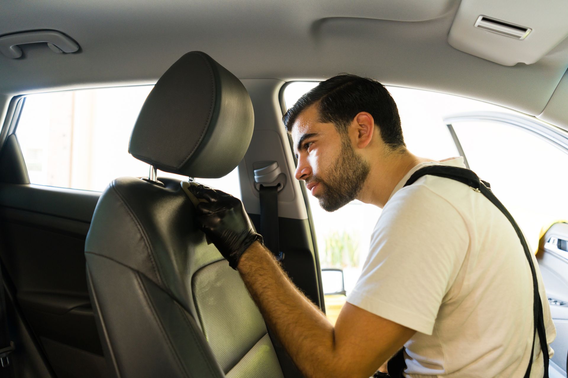 A man is cleaning the seats of a car.