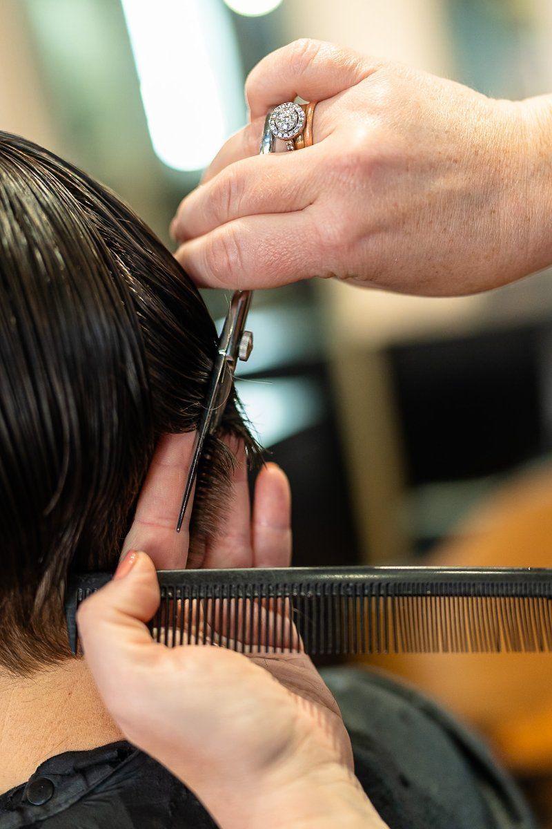 A Woman is Getting Her Hair Cut by a Hairdresser  — Air Hair Studio in Toowoomba City, QLD