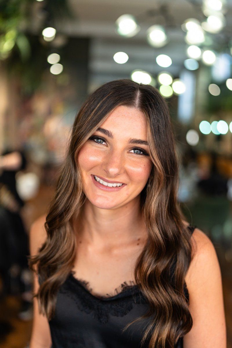 A Woman in a Black Tank Top is Smiling for the Camera — Air Hair Studio in Toowoomba City, QLD