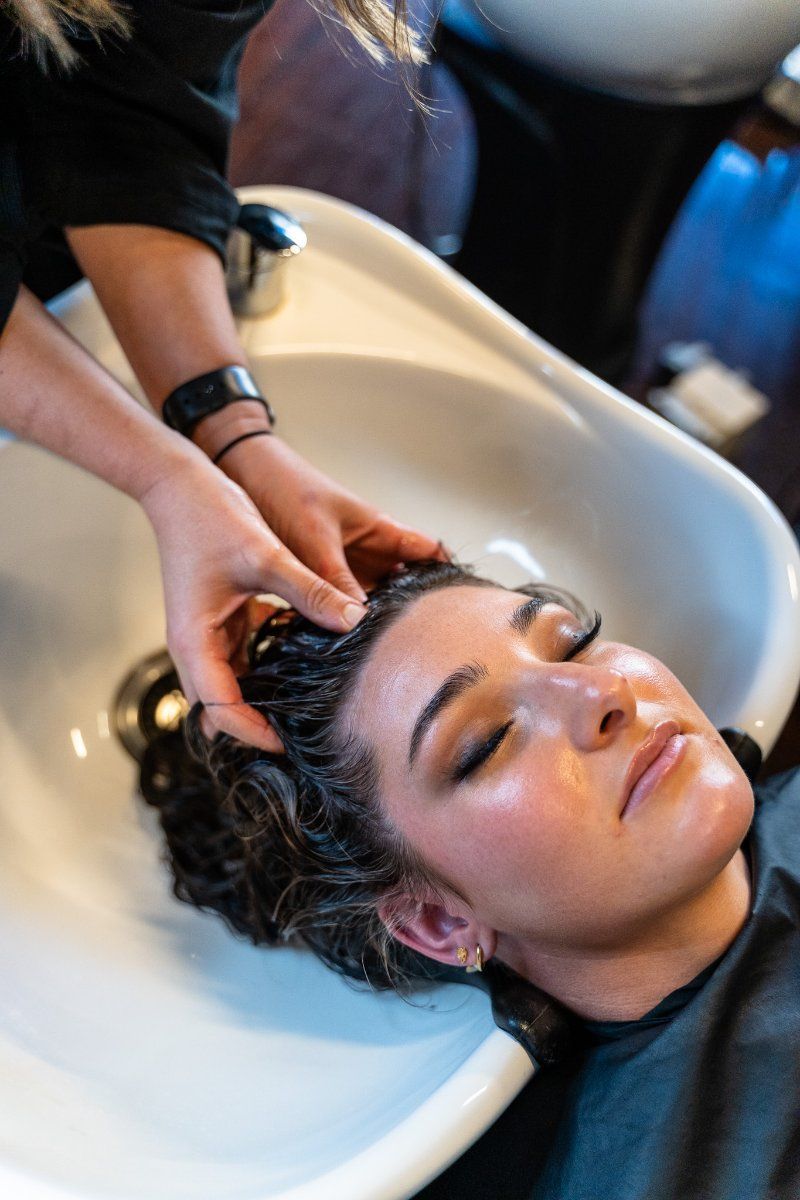 A Woman is Getting Her Hair Washed in a Sink at a Salon — Air Hair Studio in Toowoomba City, QLD