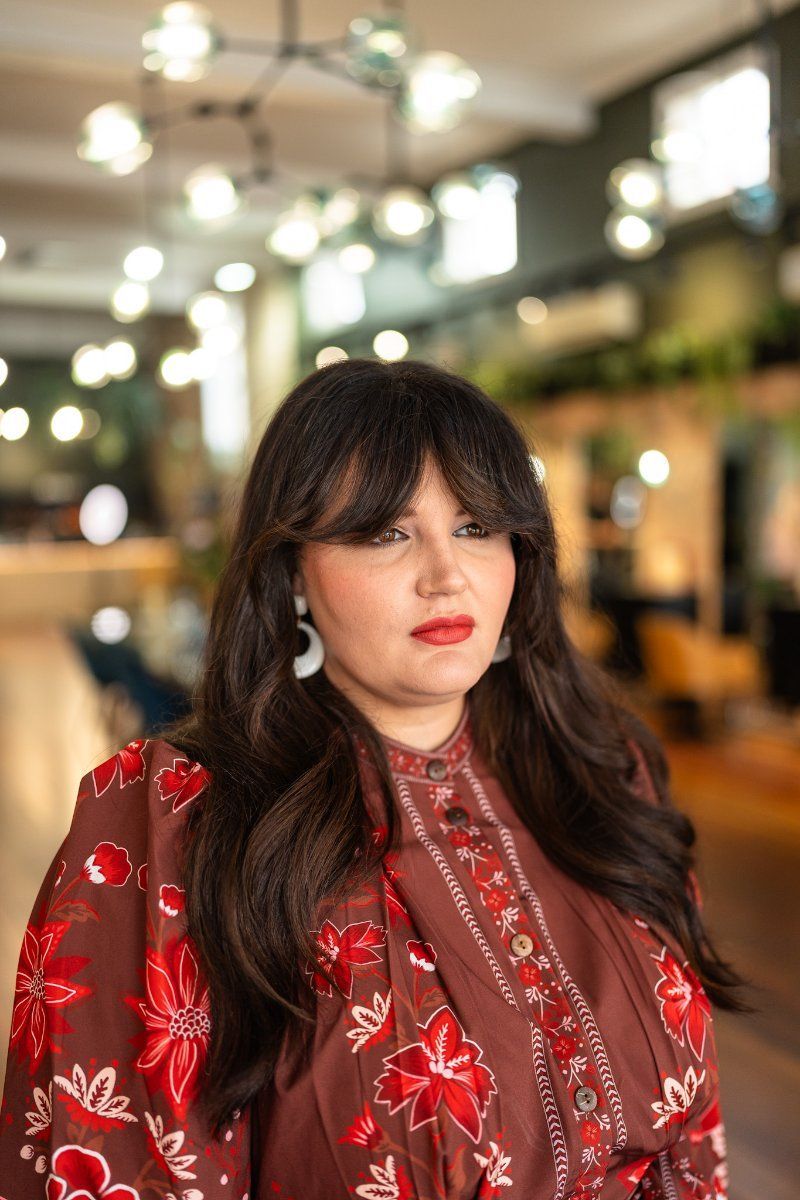 A Woman Wearing a Red Dress and Earrings is Standing in a Room — Air Hair Studio in Toowoomba City, QLD