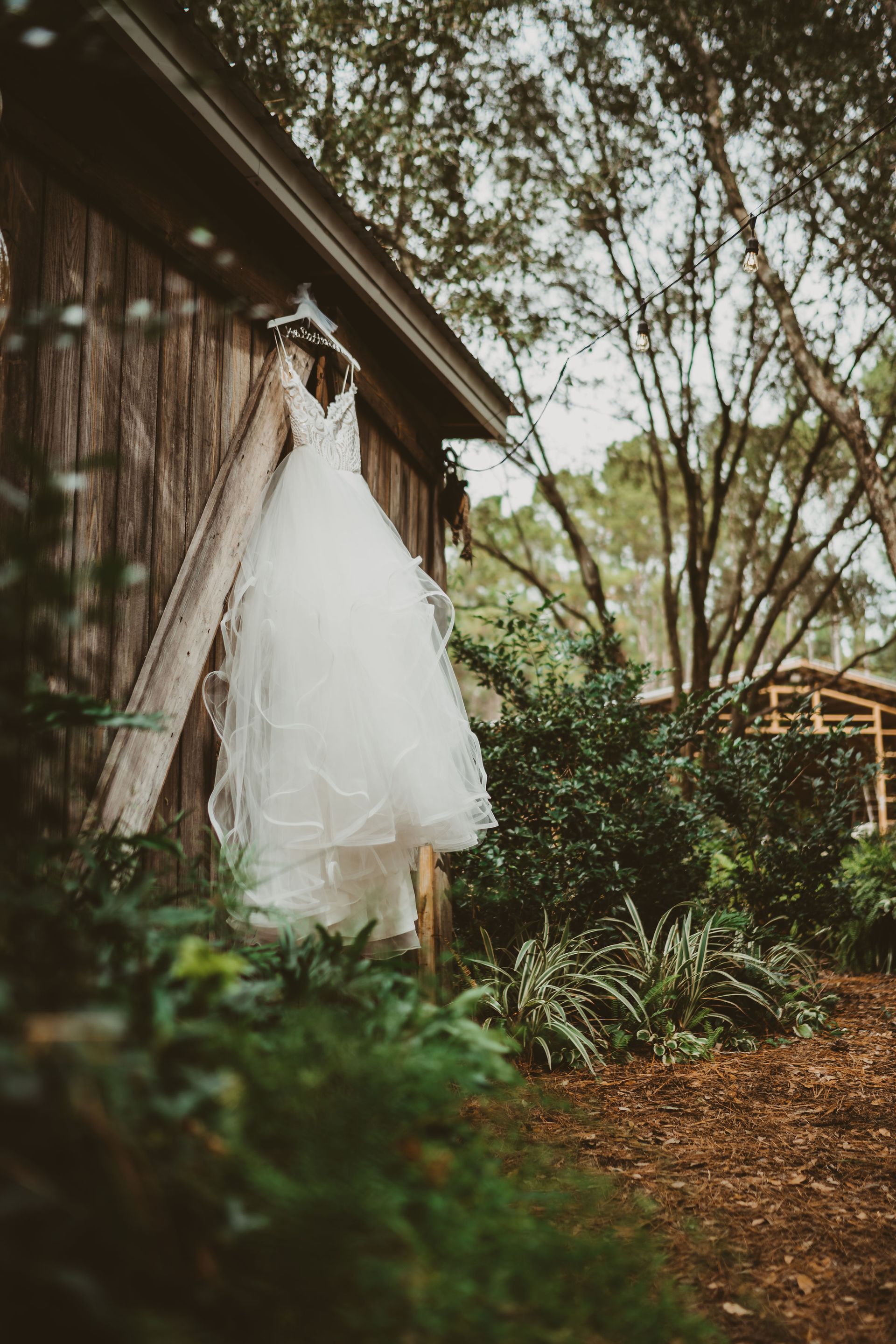 wedding gown hanging from barn venue rafter