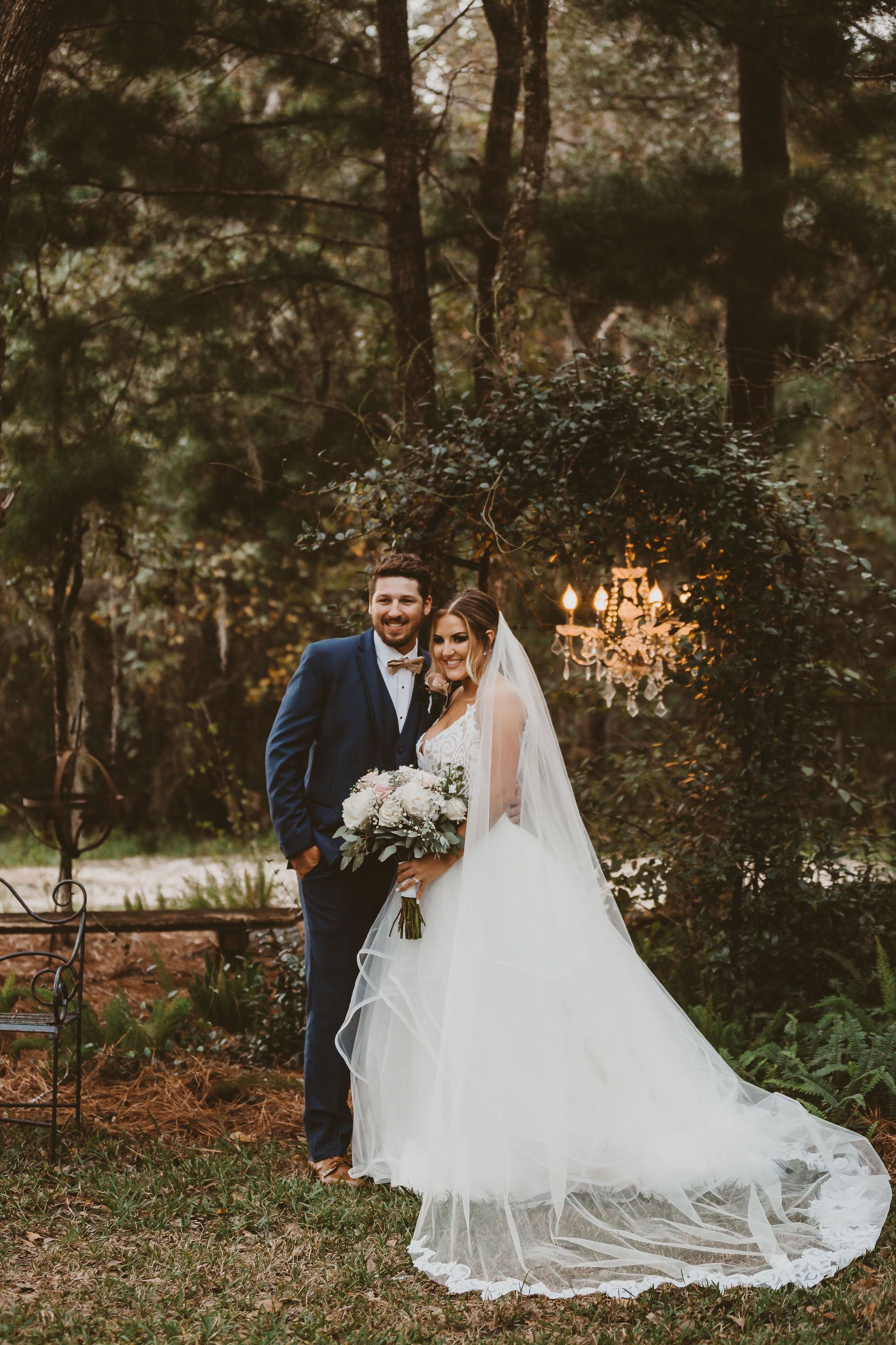 bride and groom under greenery arch