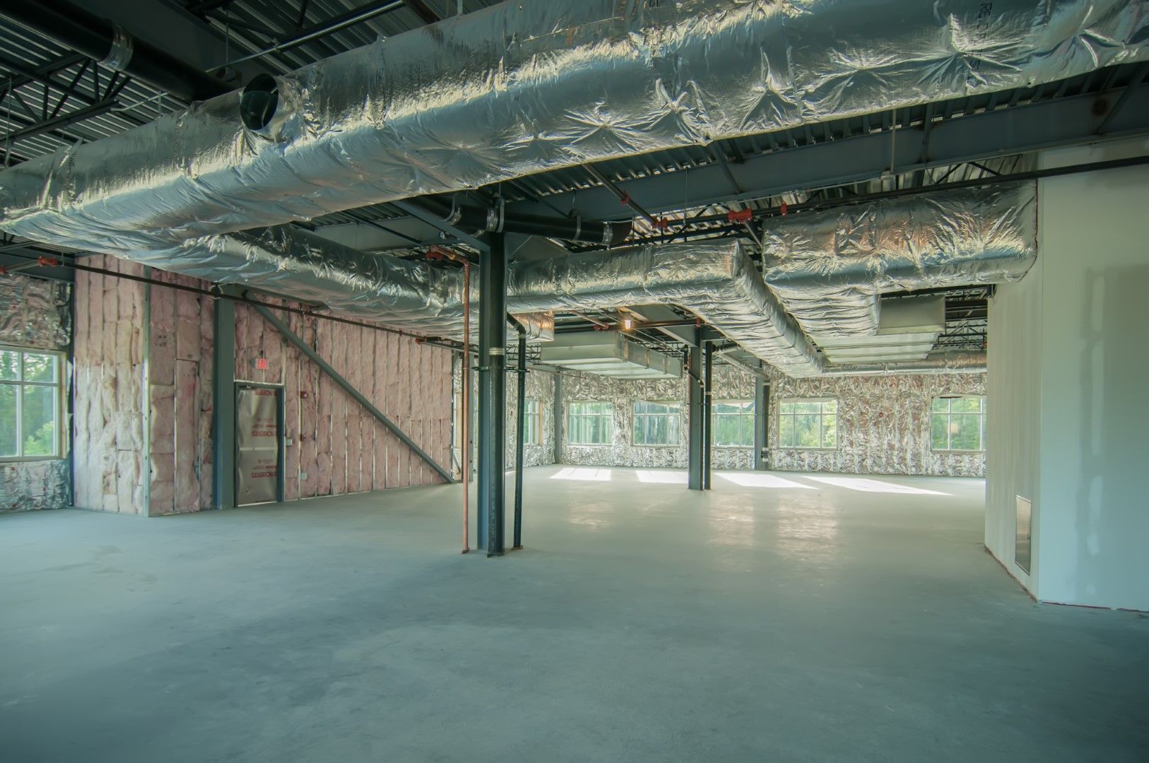Large commercial building interior with spray foam and HVAC ducts.