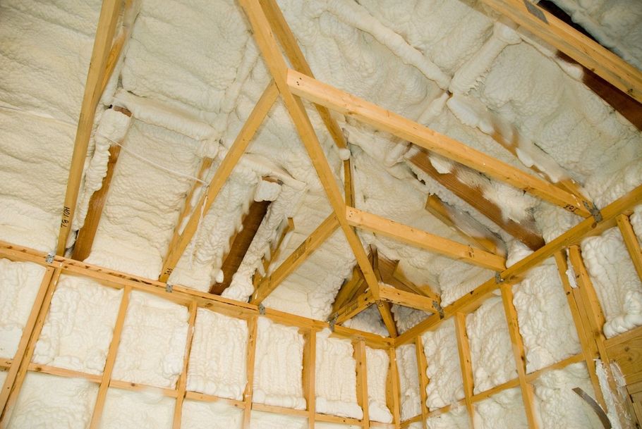 Finished residential attic with white spray foam insulation.