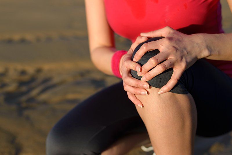 Woman holding painful knee
