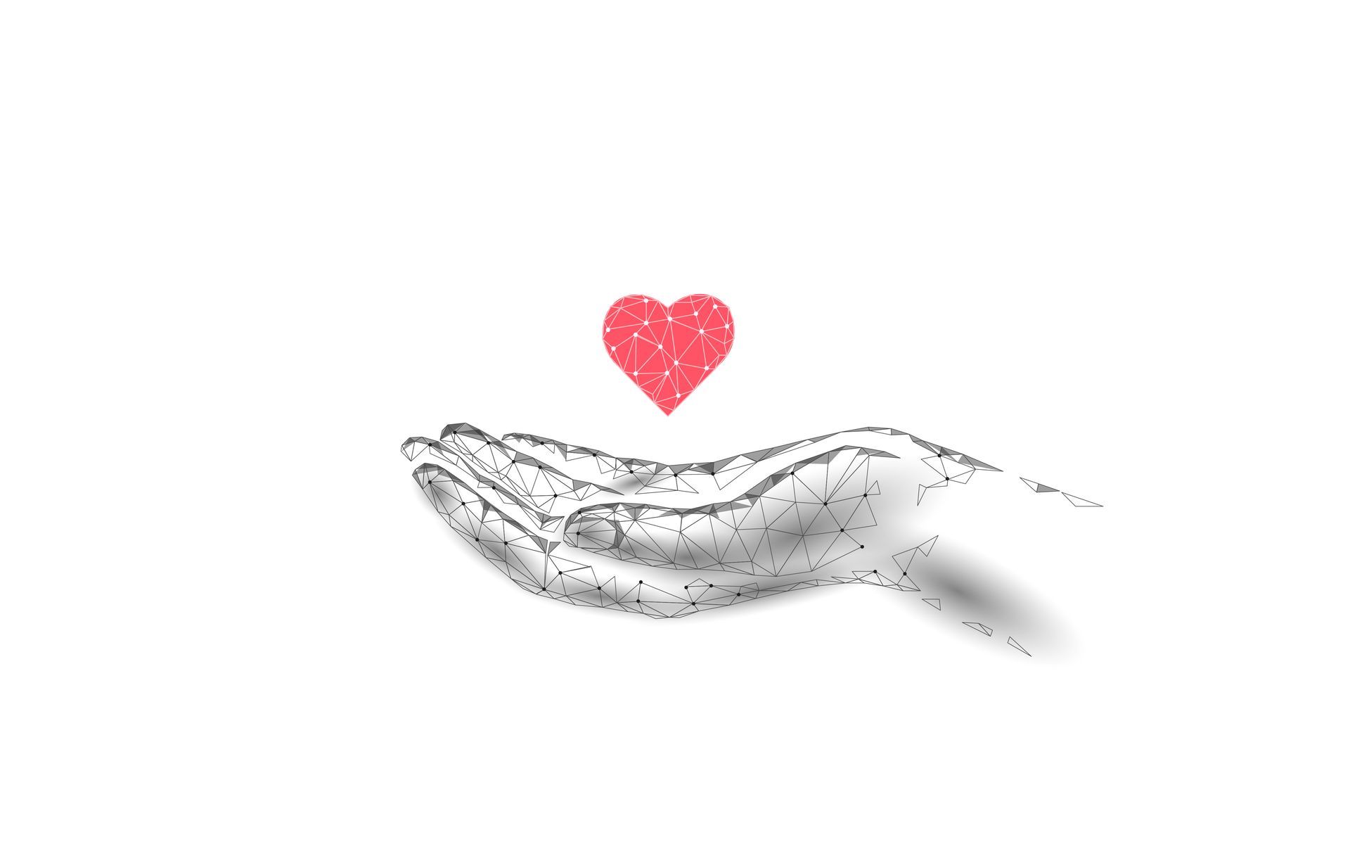 A hand is holding a red heart in its palm.