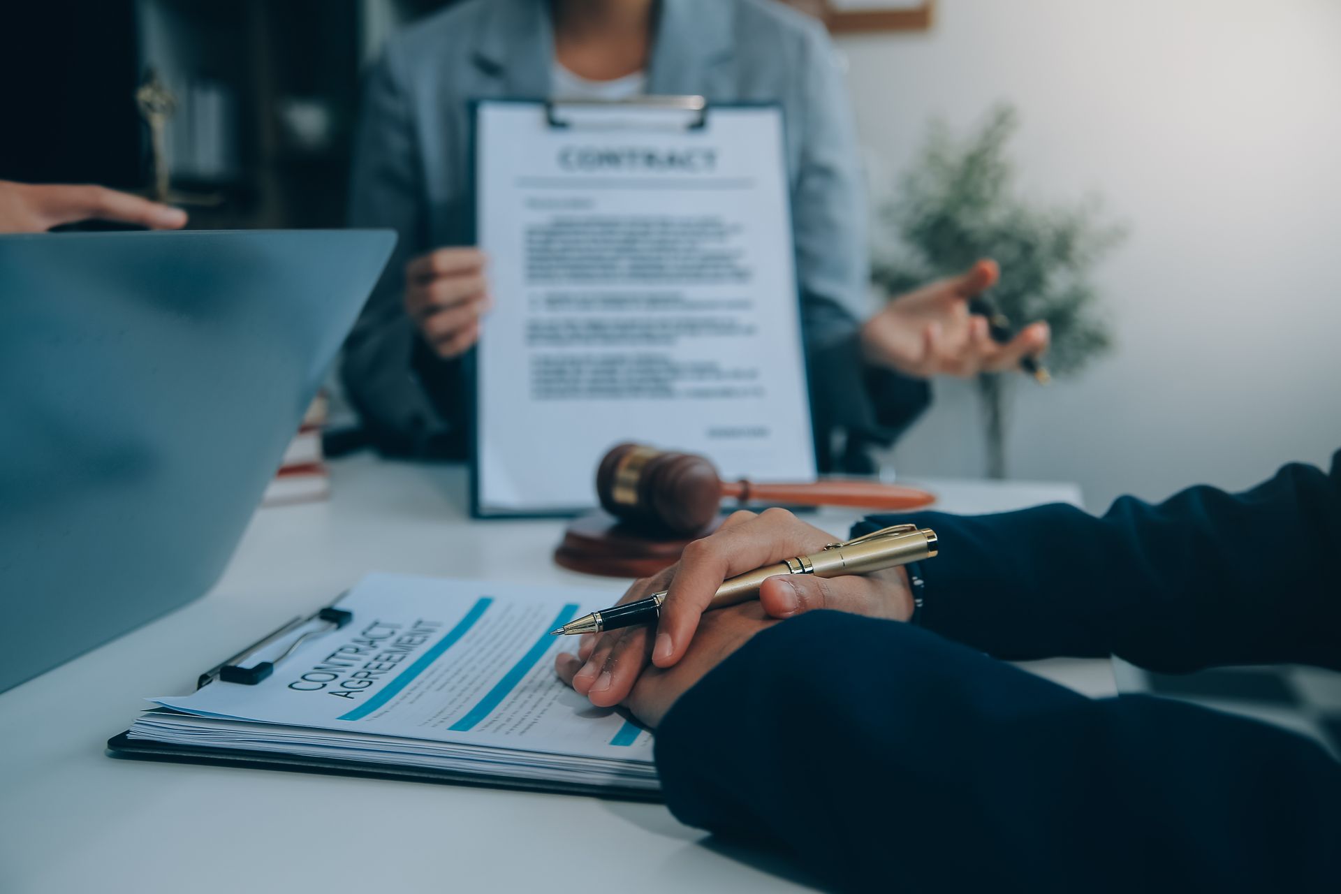 A group of people are sitting at a table signing a contract.