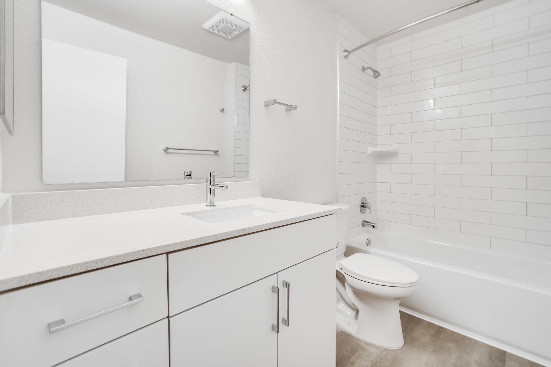 White bathroom with vanity, toilet, and bathtub/shower.