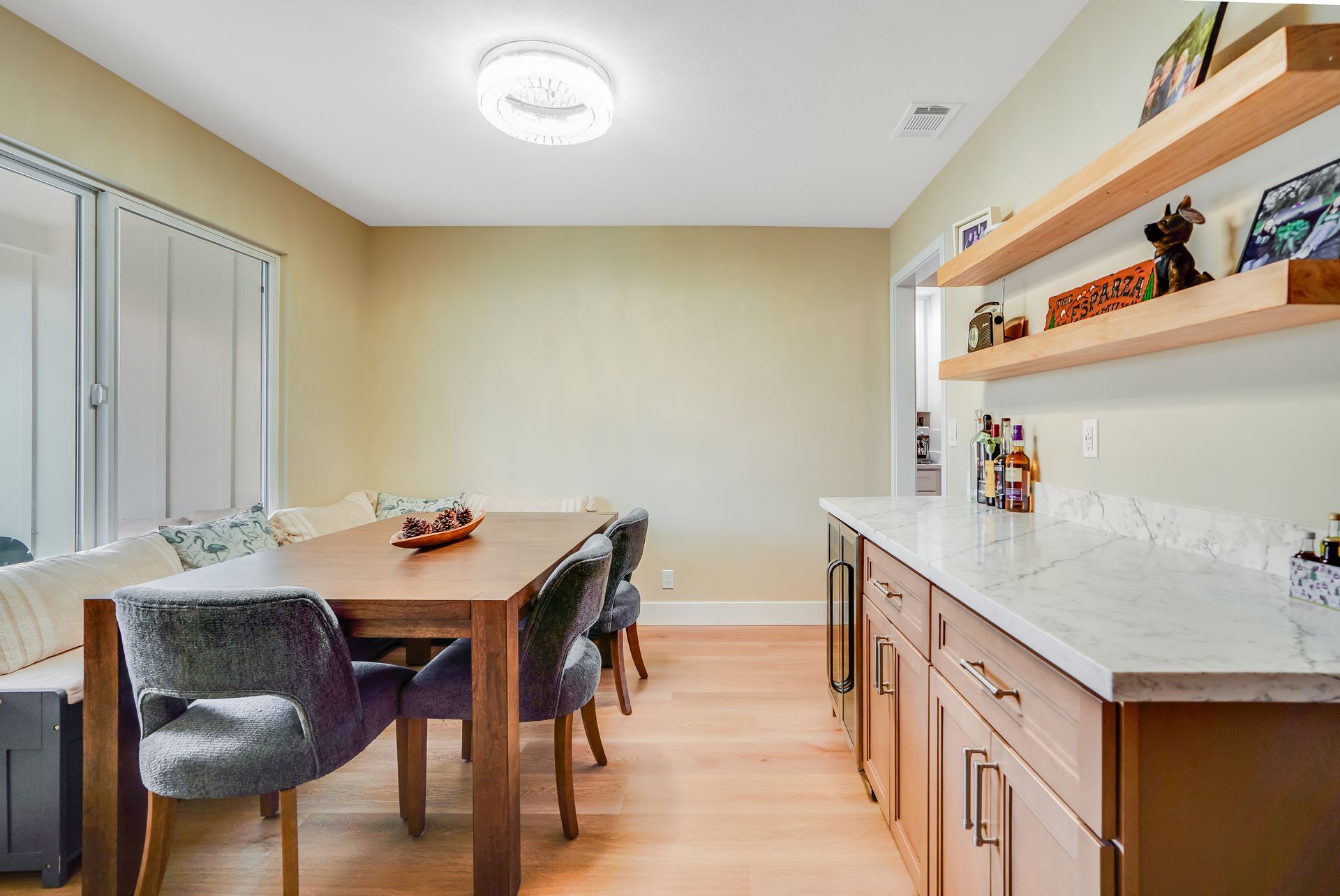 Dining room with a wooden table, built-in seating, and a side bar.