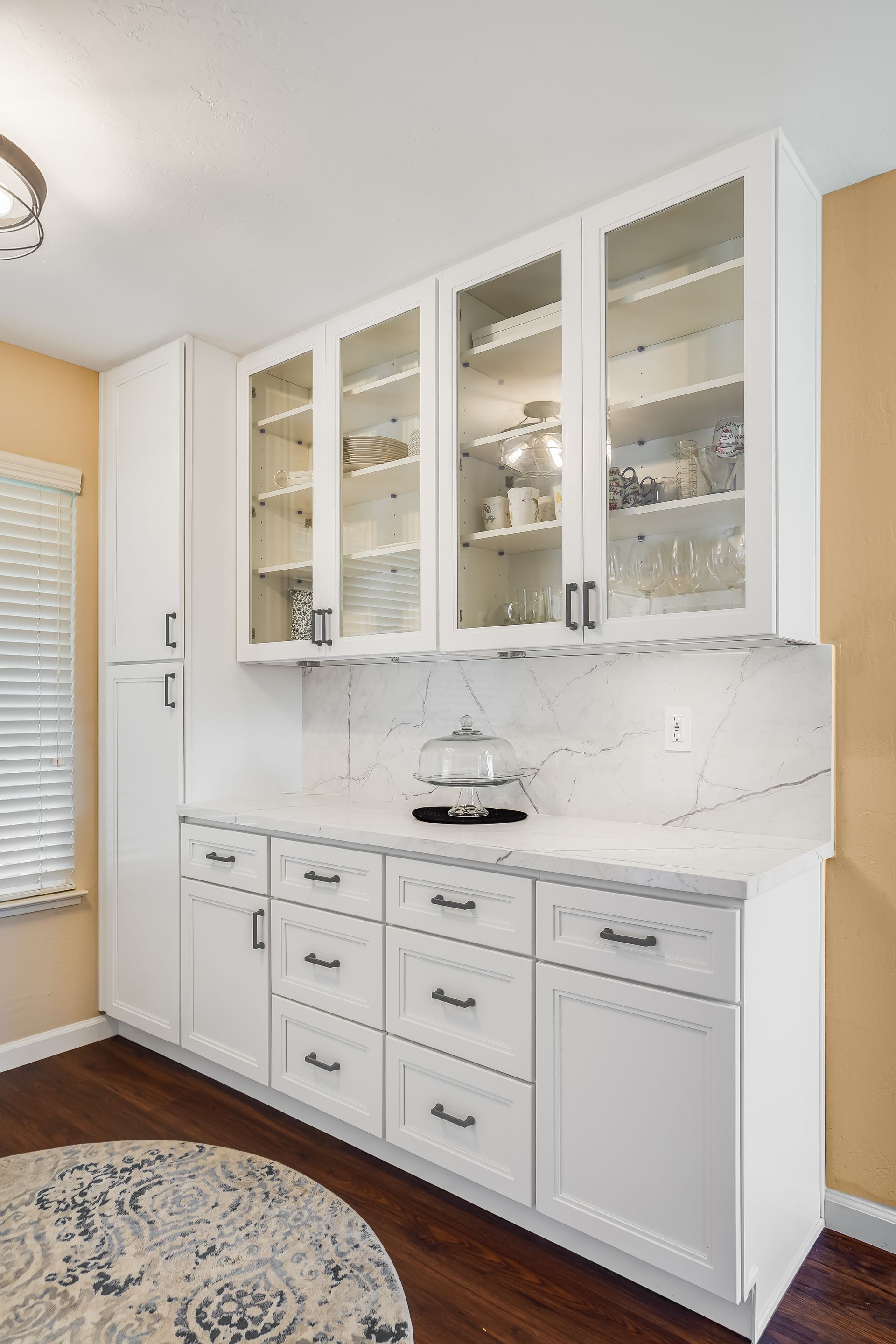 White built-in kitchen cabinetry with glass-front uppers, countertop, and lower drawers.