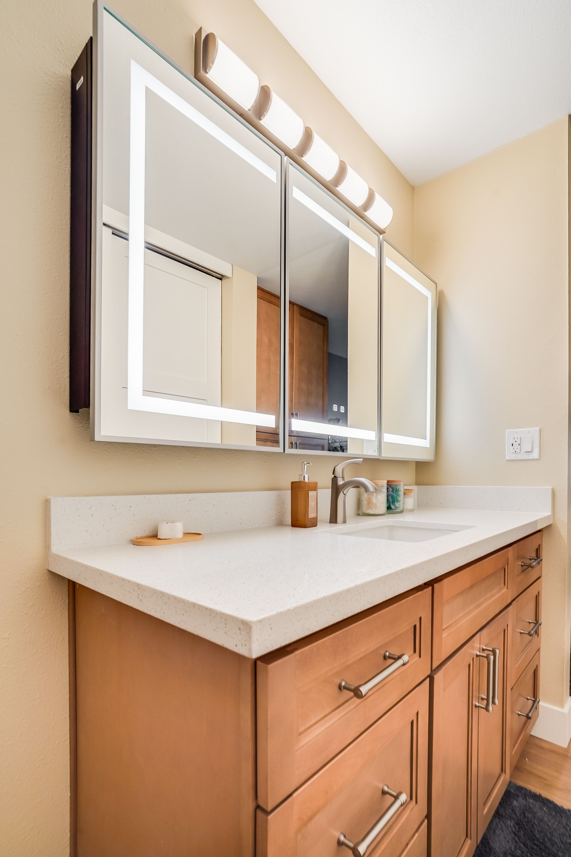 Bathroom vanity with light wood cabinets.