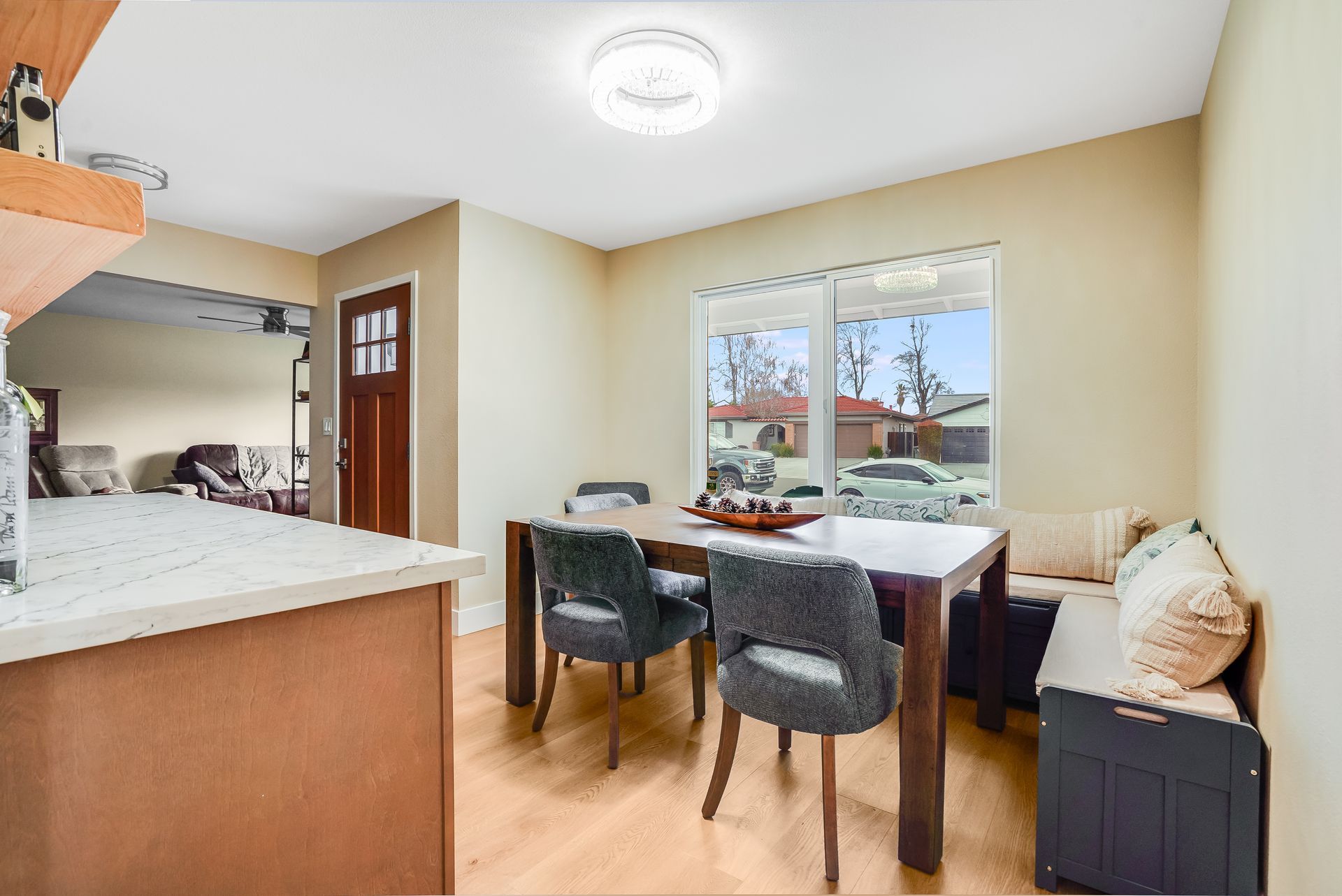 Dining area with wood table, gray chairs, built-in bench, and a window.