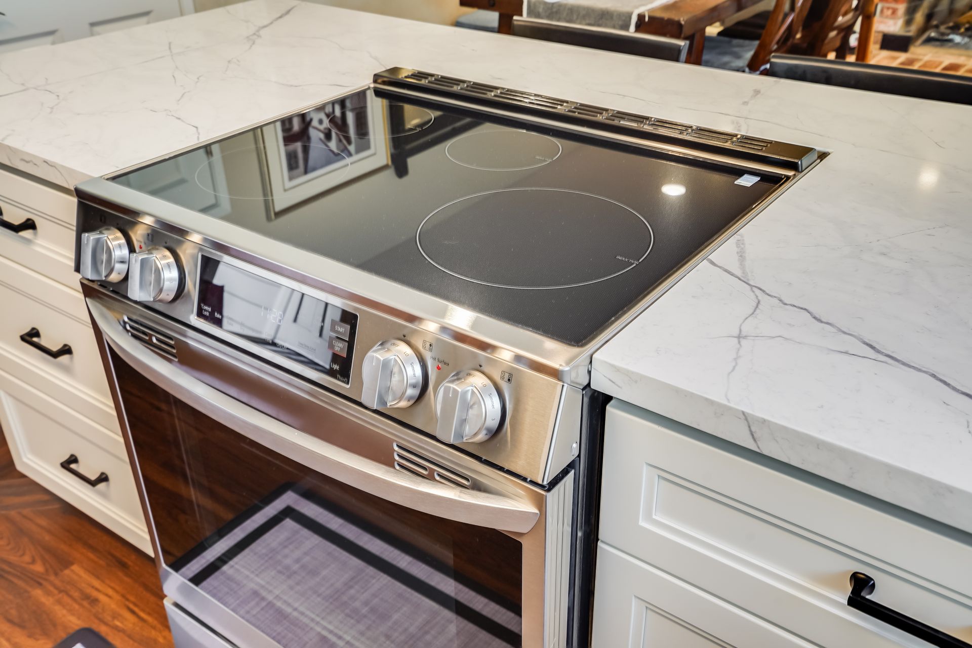 Stainless steel electric range built into a white countertop. 