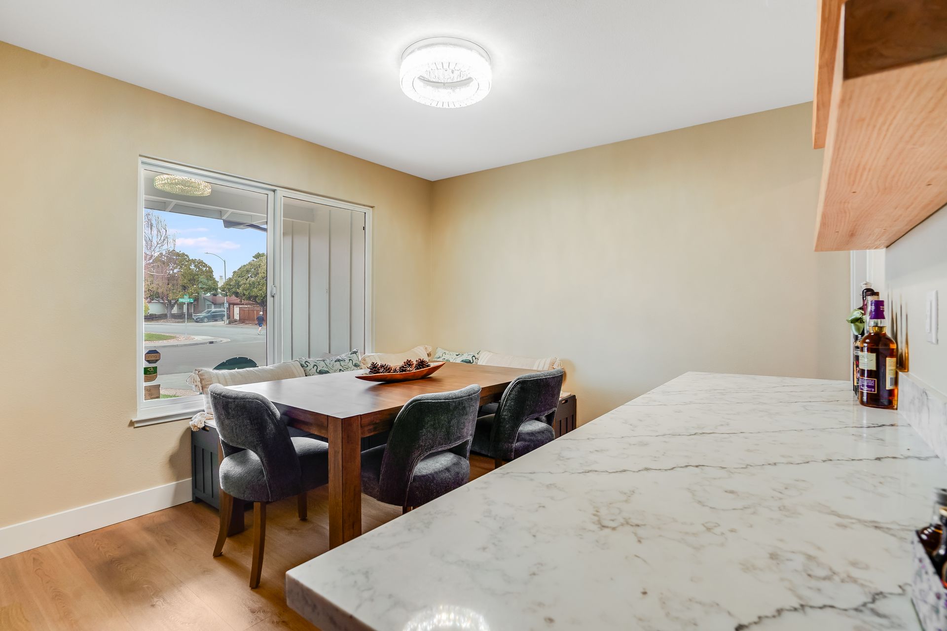 Dining area with a wooden table and chairs by a window. 