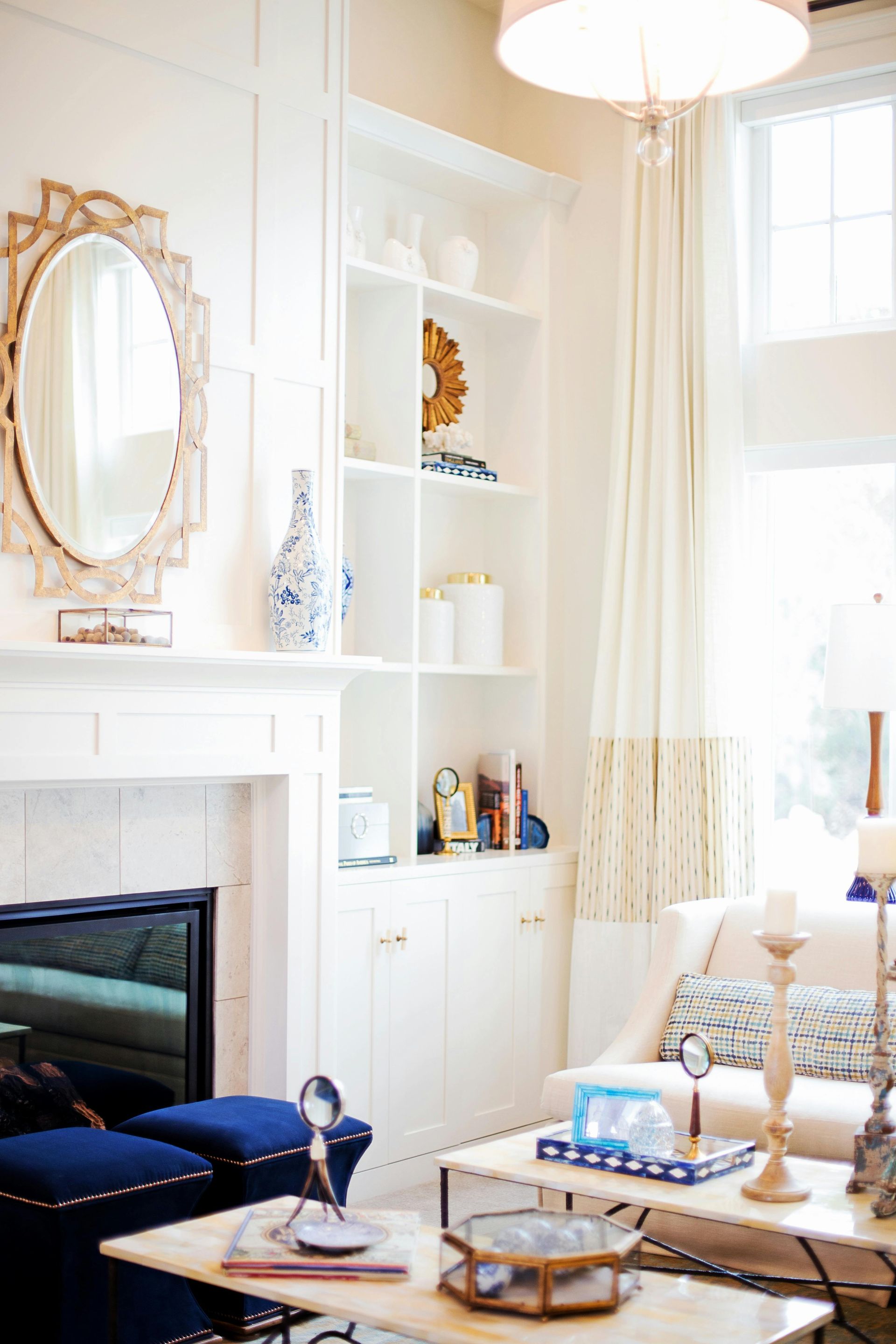 White living room with fireplace, built-in shelving, and light-colored furnishings.