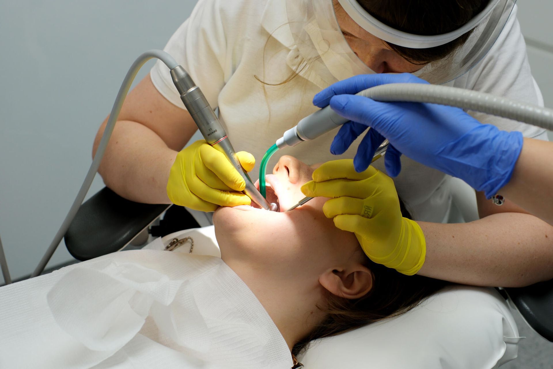 A woman is getting her teeth examined by a dentist.