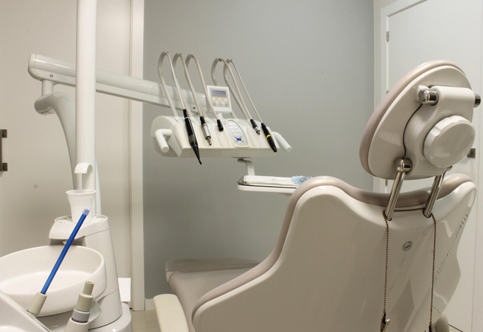 A dental office with a dental chair and a sink