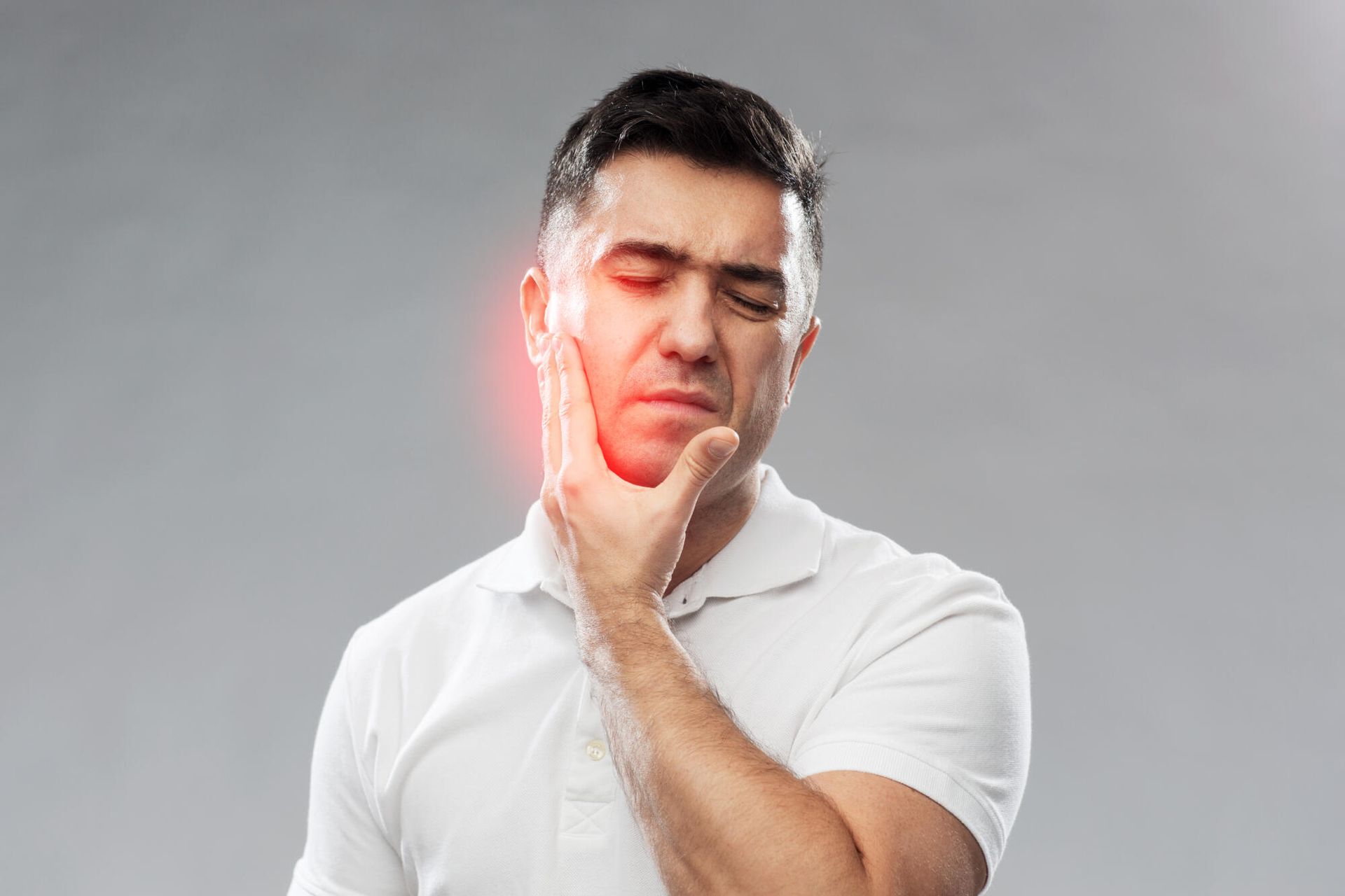 A man is holding his face in pain because of a toothache.