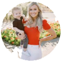 Woman holding a child outdoors, both smiling, with a bright, circular blurred background.