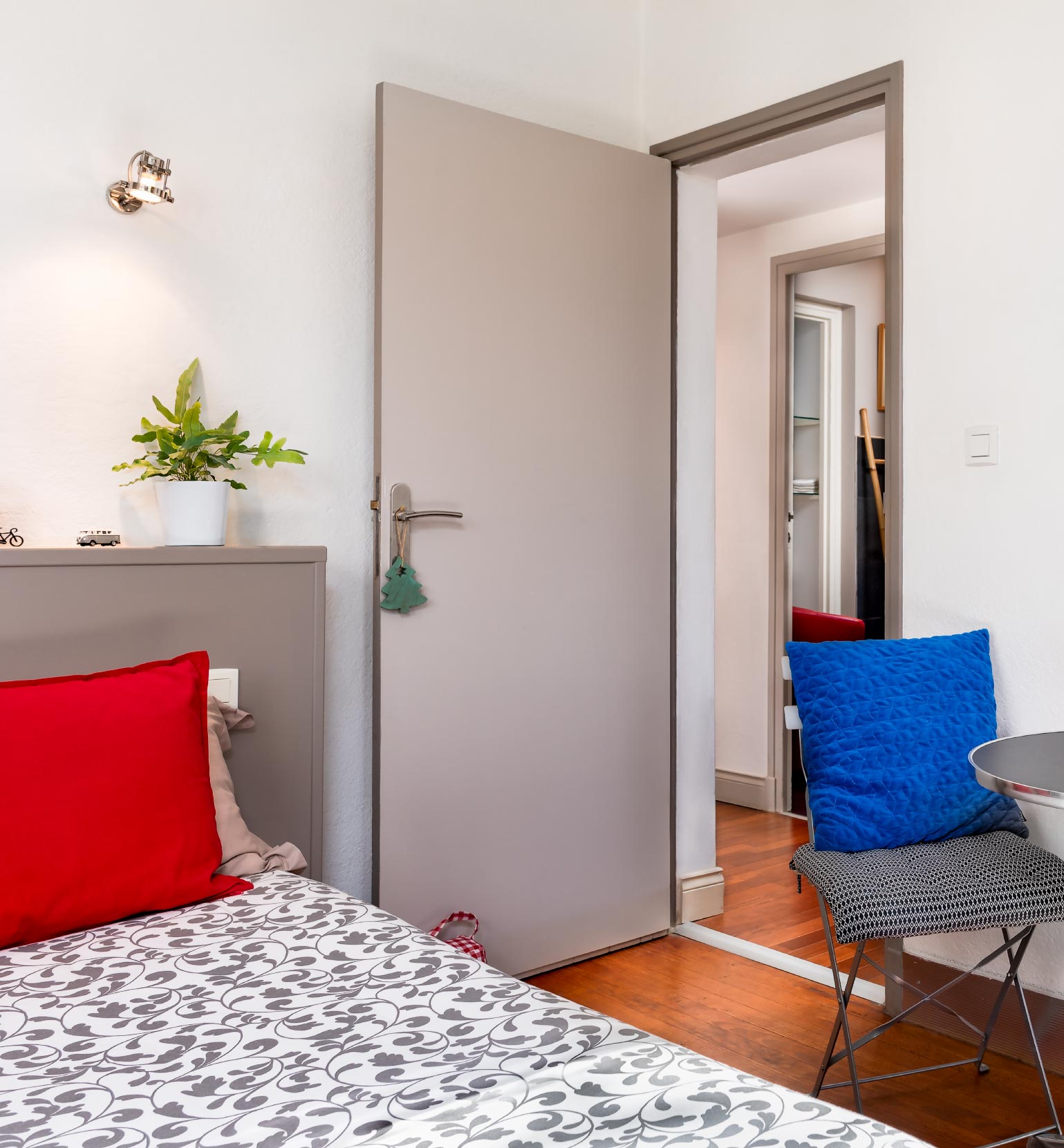 Chambre Charleston Gray, coussin rouge, coussin bleu