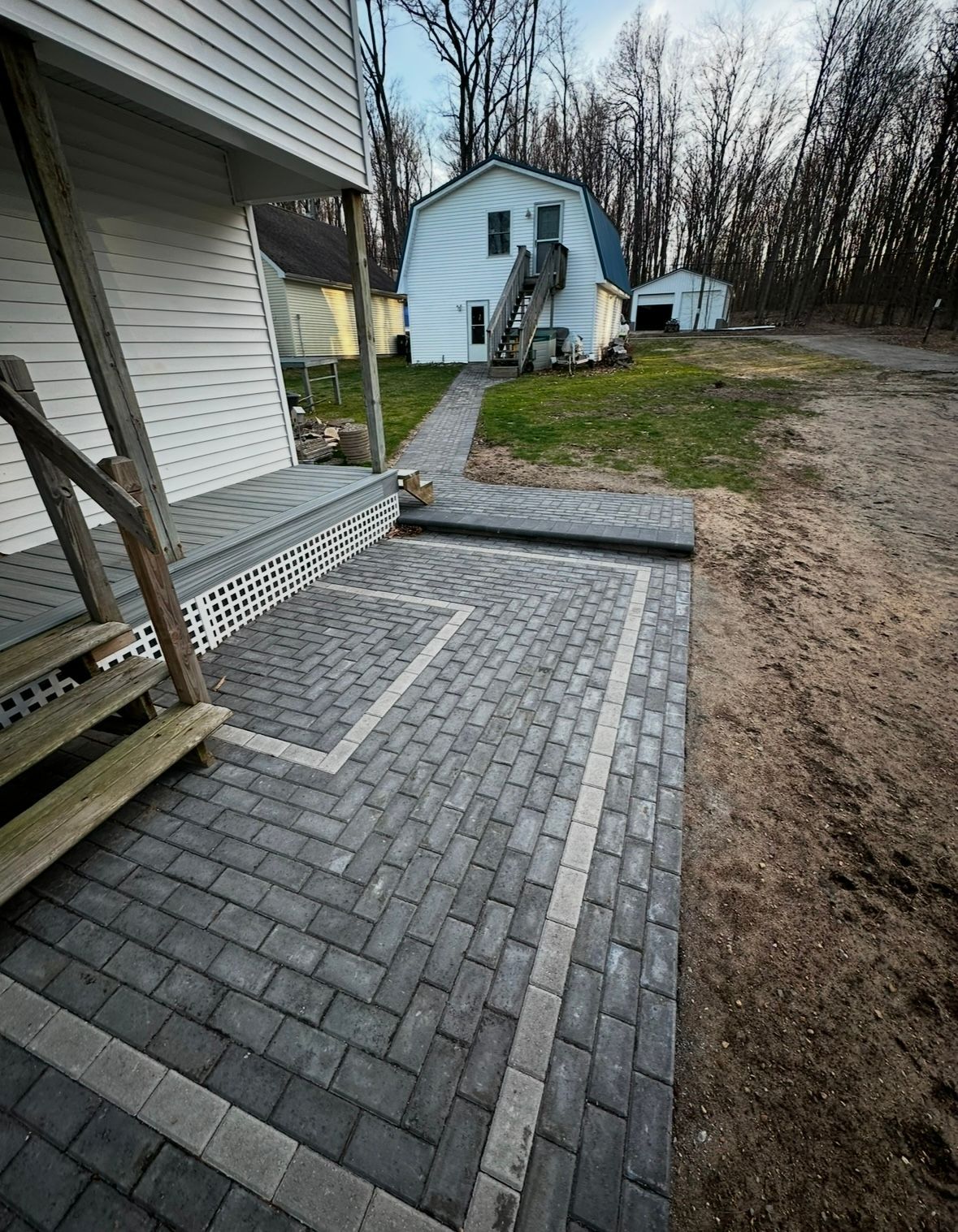 The front of a house with a large porch and black shutters.