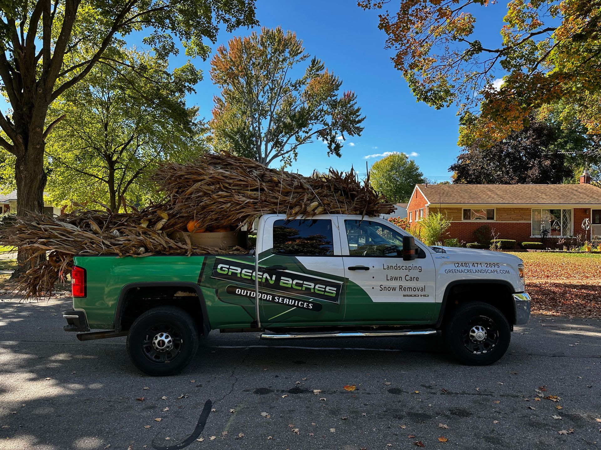Gray house with manicured lawn and colorful flower beds.