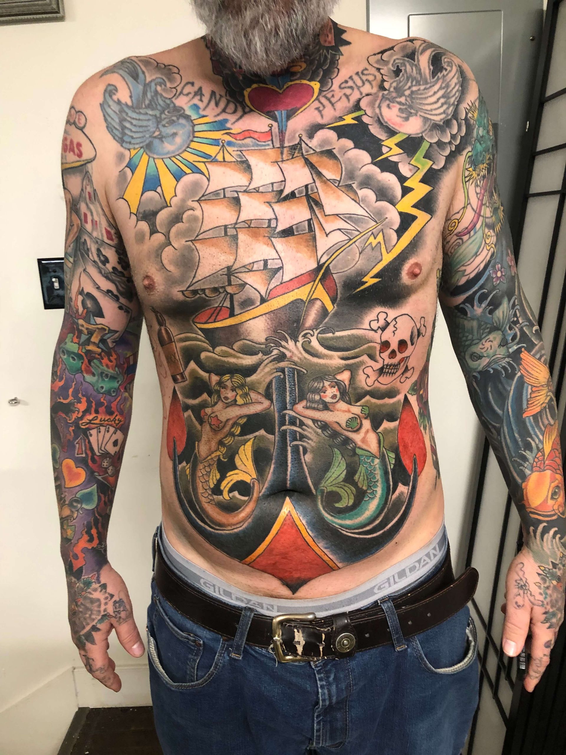 A shirtless man with a lot of tattoos on his body