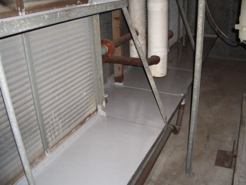 Metal structure with light gray flooring and pipes in an industrial setting.