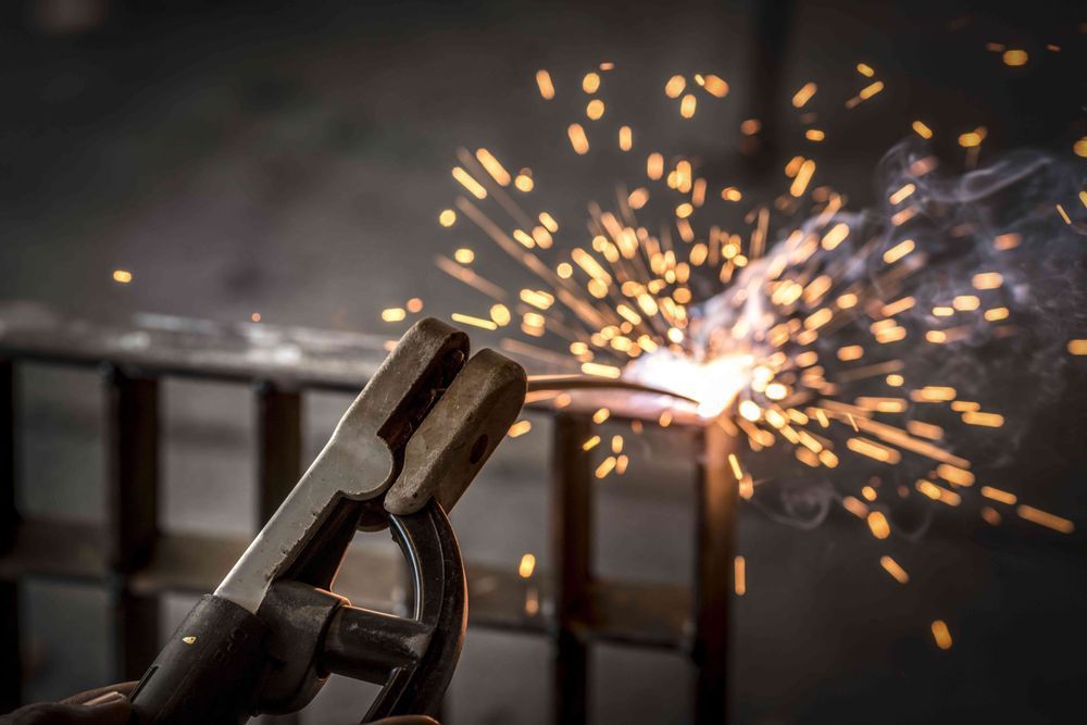 A person is welding a piece of metal with sparks coming out of it.