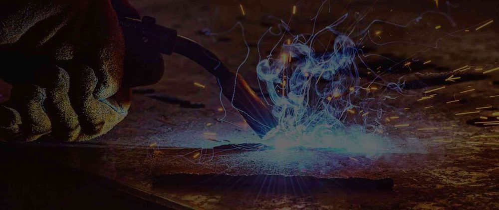 A close up of a person welding a piece of metal.