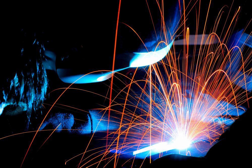 A person is welding a piece of metal with sparks coming out of it.