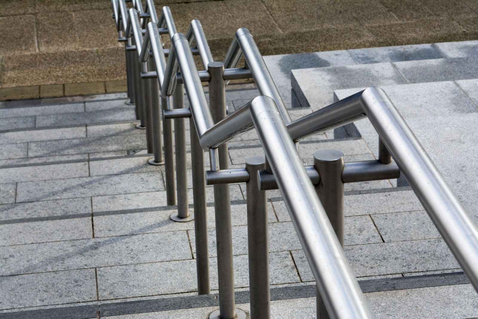 A row of stainless steel railings on a set of stairs