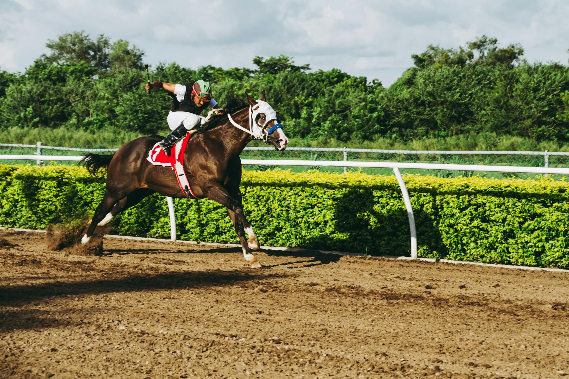 A man is riding a horse on a dirt track.