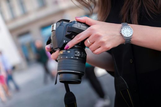A woman is pointing at a camera while wearing a watch.