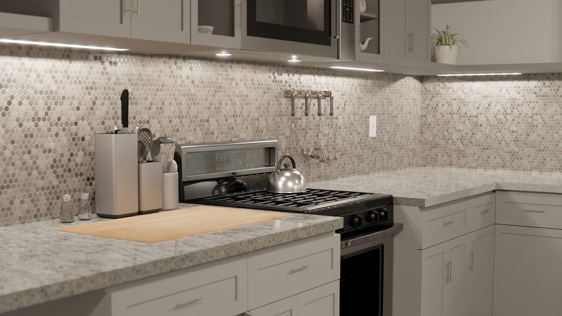 Kitchen with gray cabinets, countertop, stove, and mosaic backsplash with under-cabinet lighting.