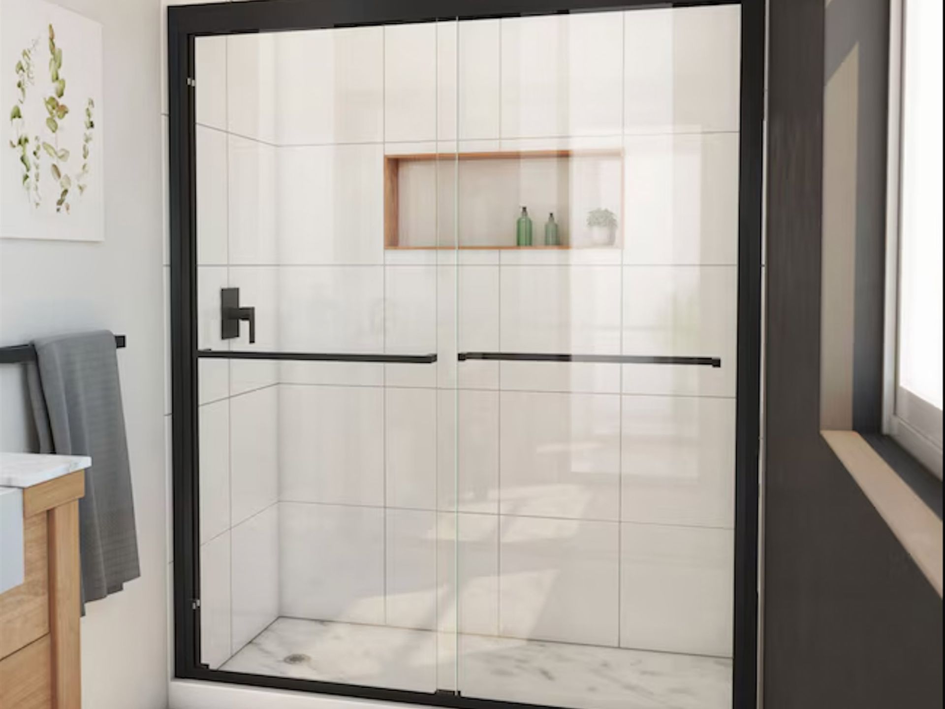 Black-framed glass shower enclosure with sliding doors. White tiled walls, recessed shelf, and matte black hardware.