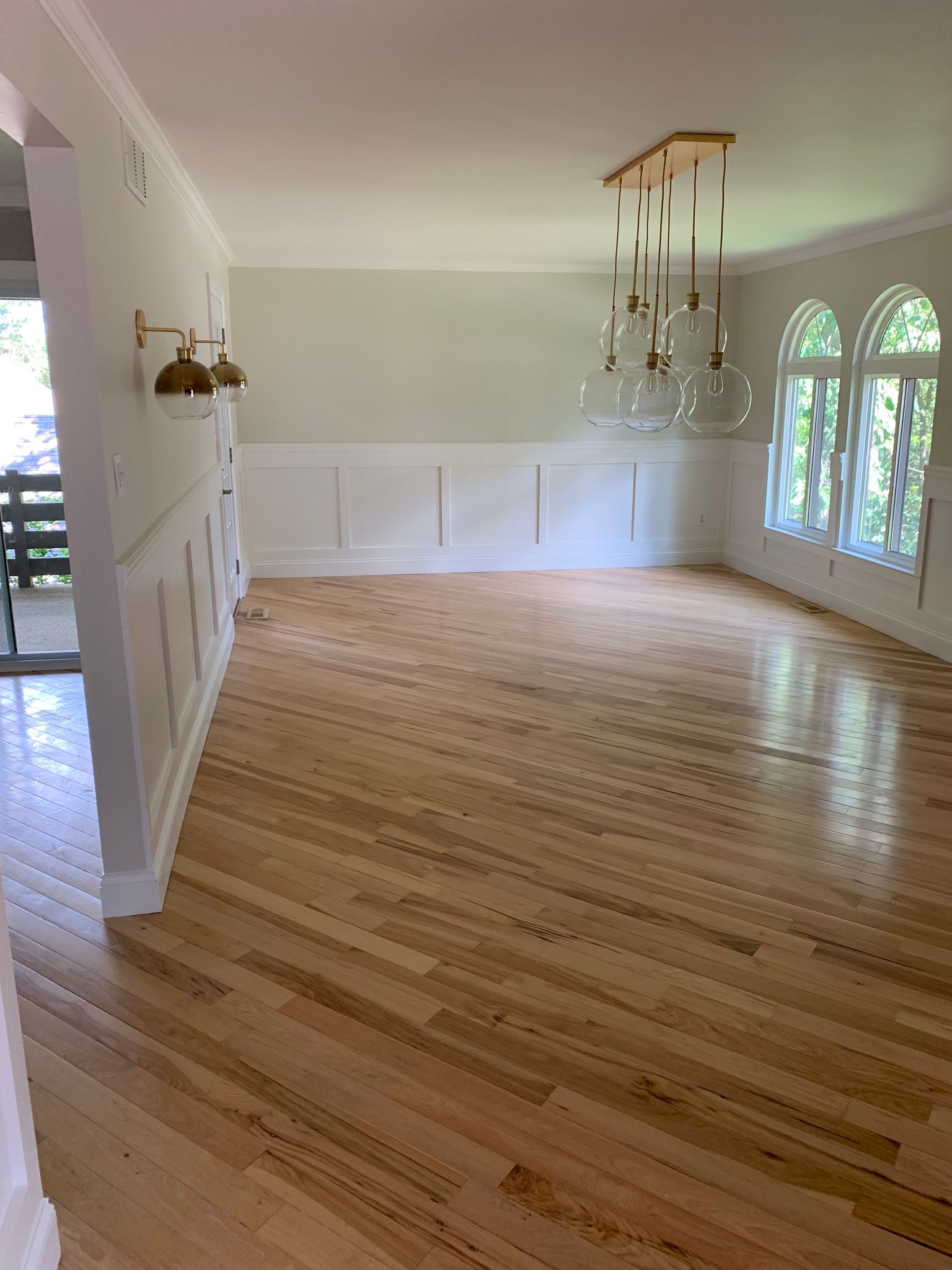 A man is standing on a ladder and plastering a ceiling.