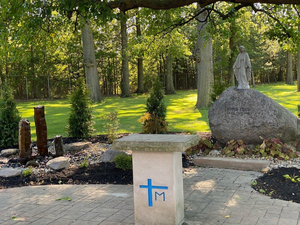 A stone pillar with a blue cross and the letter m painted on it