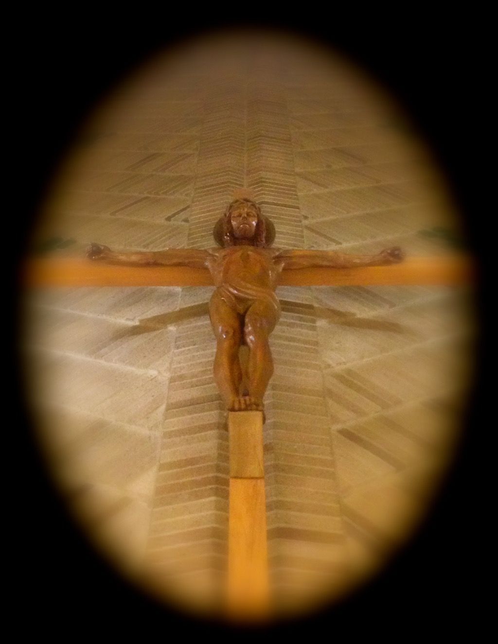 A wooden statue of jesus on the cross in a church.